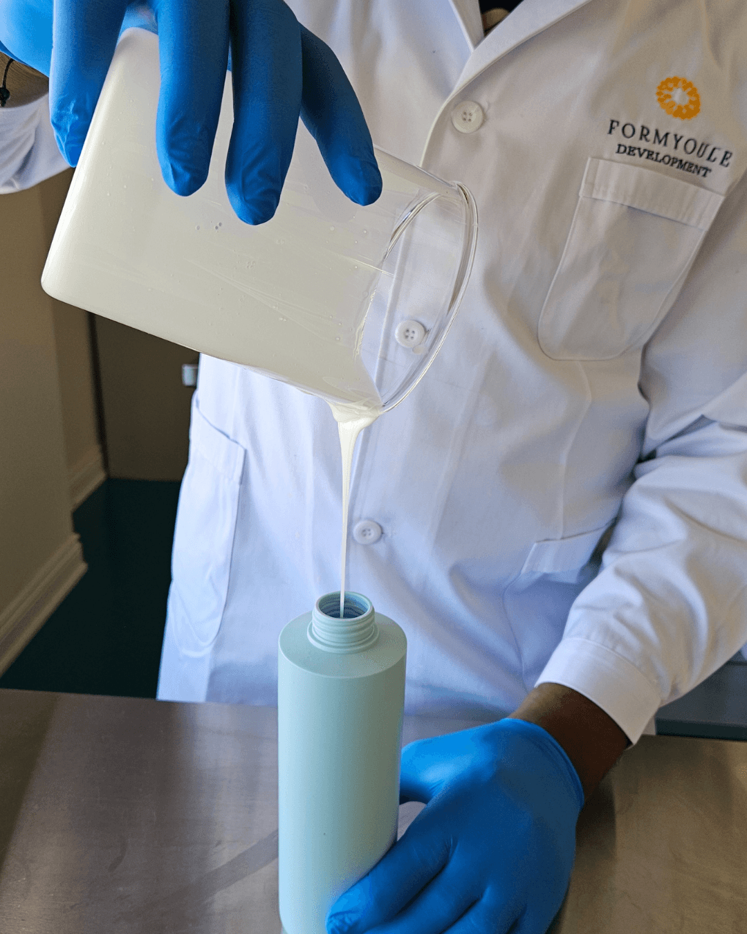 Formyoule™ Inc. boutique cosmetic lab — gloved hands formulating in the Toronto lab