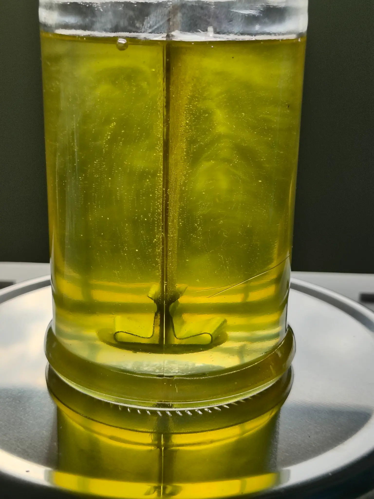 Yellow wax poured into a wick-centred glass massage-candle jar