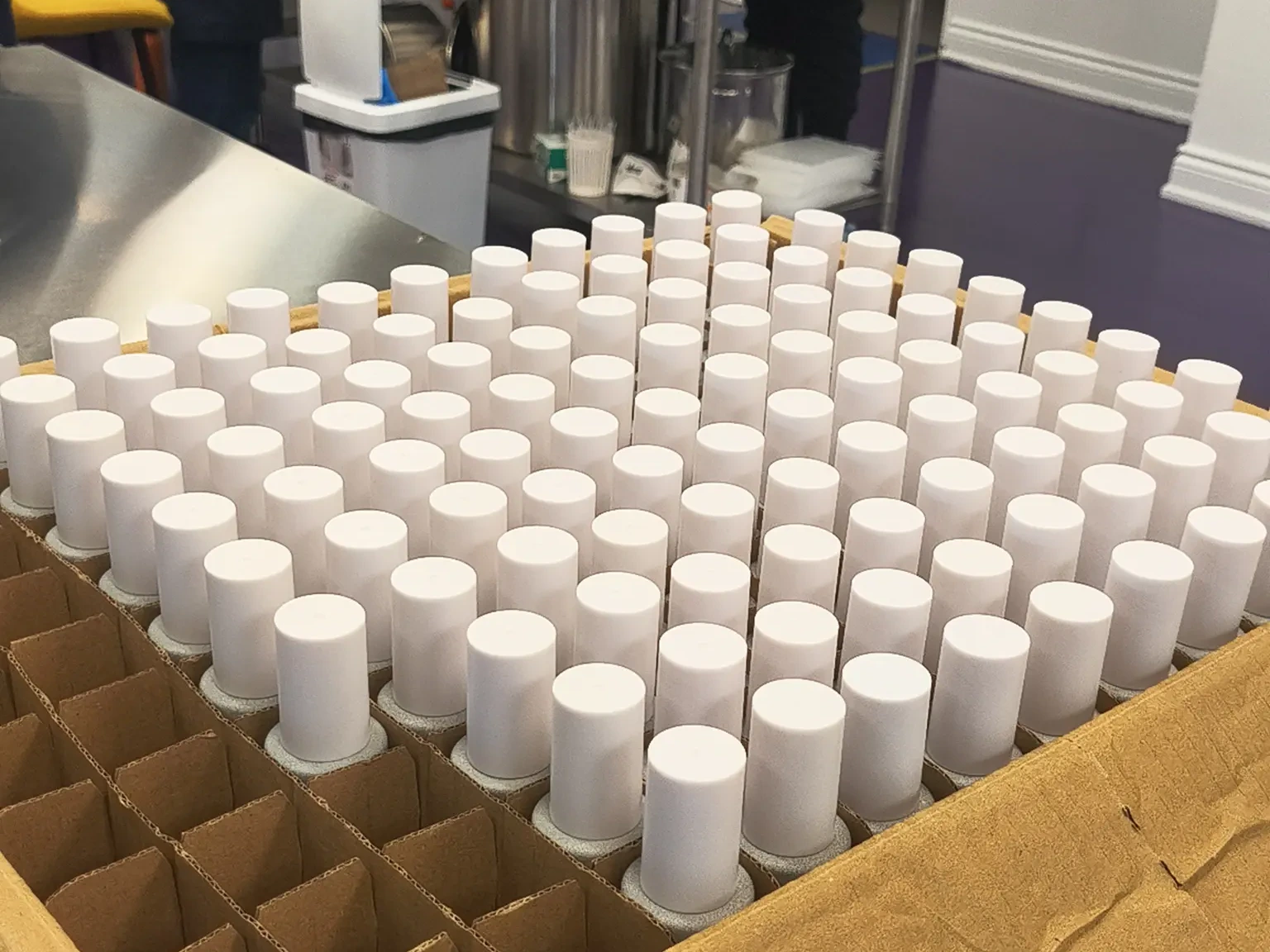 Finished white bottles in production separators on a Formyoule&trade; Inc. lab work table