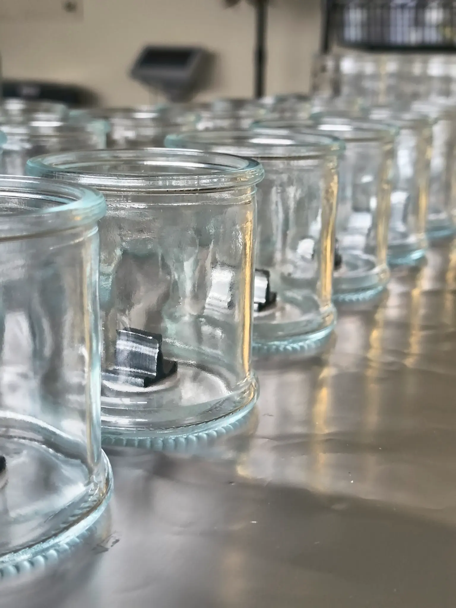 Tarros de vidrio preparados con mecha para una producción de velas de masaje de spa boutique